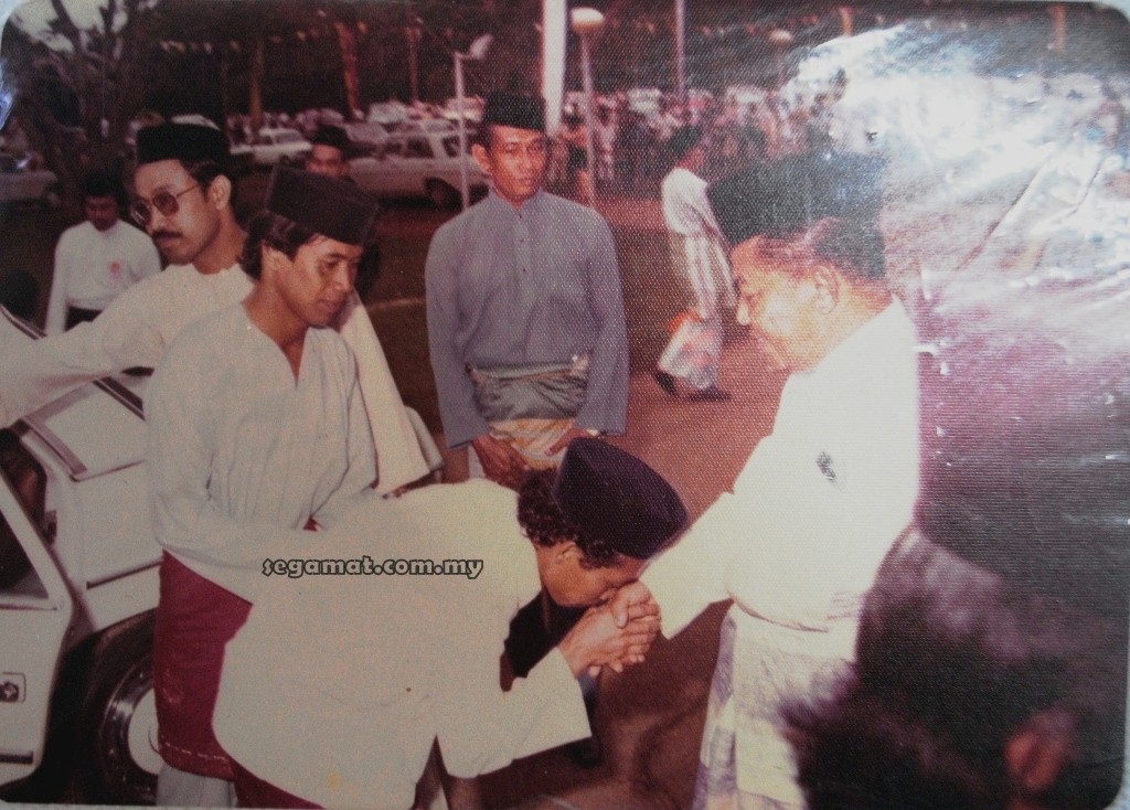 Salah seorang pengantin lelaki bersalaman dengan Tan Sri Othman Saat (kanan)