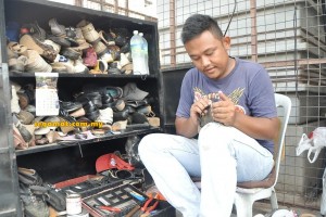 Mohammad Fikri tekun membaiki kasut pelanggannya