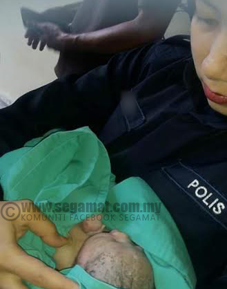 Anggota polis bertugas memangku bayi di Hospital Daerah Segamat | Kredit Foto Group Whatsapp Kampung Jawa