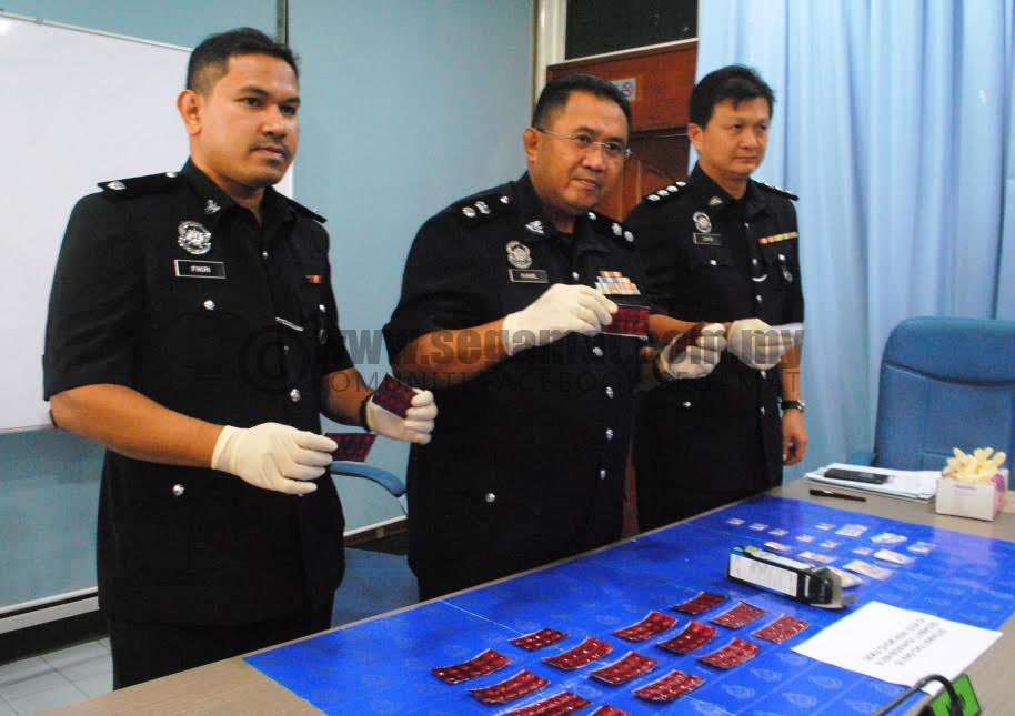 Mohd Kamil (tengah) menunjukkan dadah yang berjaya dirampas.