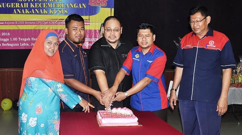 Mohd Azahar (tengah) memotong kek selepas merasmikan Program Motivasi dan Anugerah Kecemerlangan Anak-Anak Ahli Kelab Usahawan Sahabat Ikhtiar Segamat.